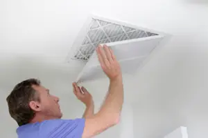 A man checking an air filter in a Prosper, TX home.