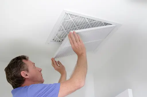 A man checking an air filter in a Prosper, TX home.